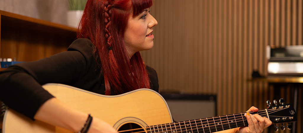 Woman playing Harley Benton Acoustic Guitar