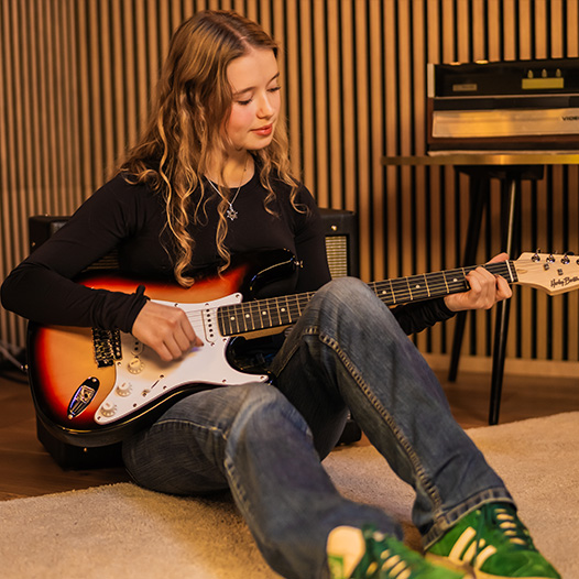 Girl learning on Harley Benton Guitar