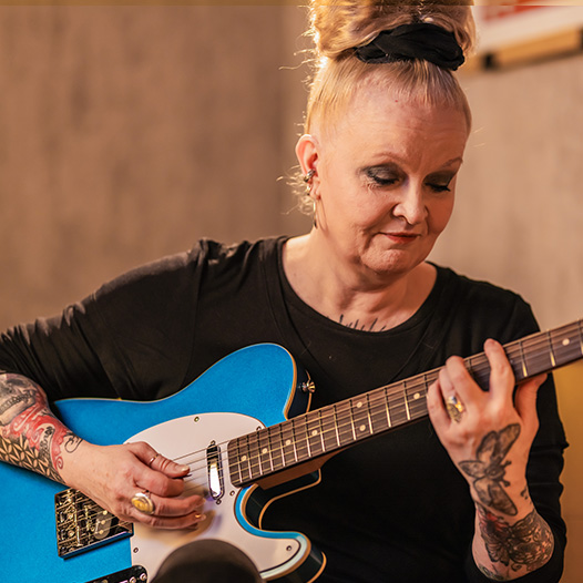 Older woman learning Harley Benton electric guitar